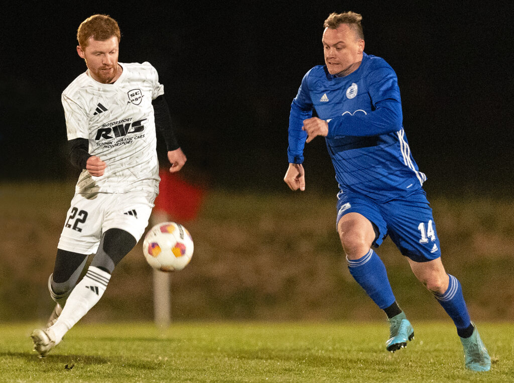 Angers Tom Berger (links), der mit einem Traum-Freistoß den 1:1-Ausgleich und -Endstand erzielte, im Leder-Wettstreit gegen Wagings Andreas Kamml ((C) Hans-Joachim Bittner).