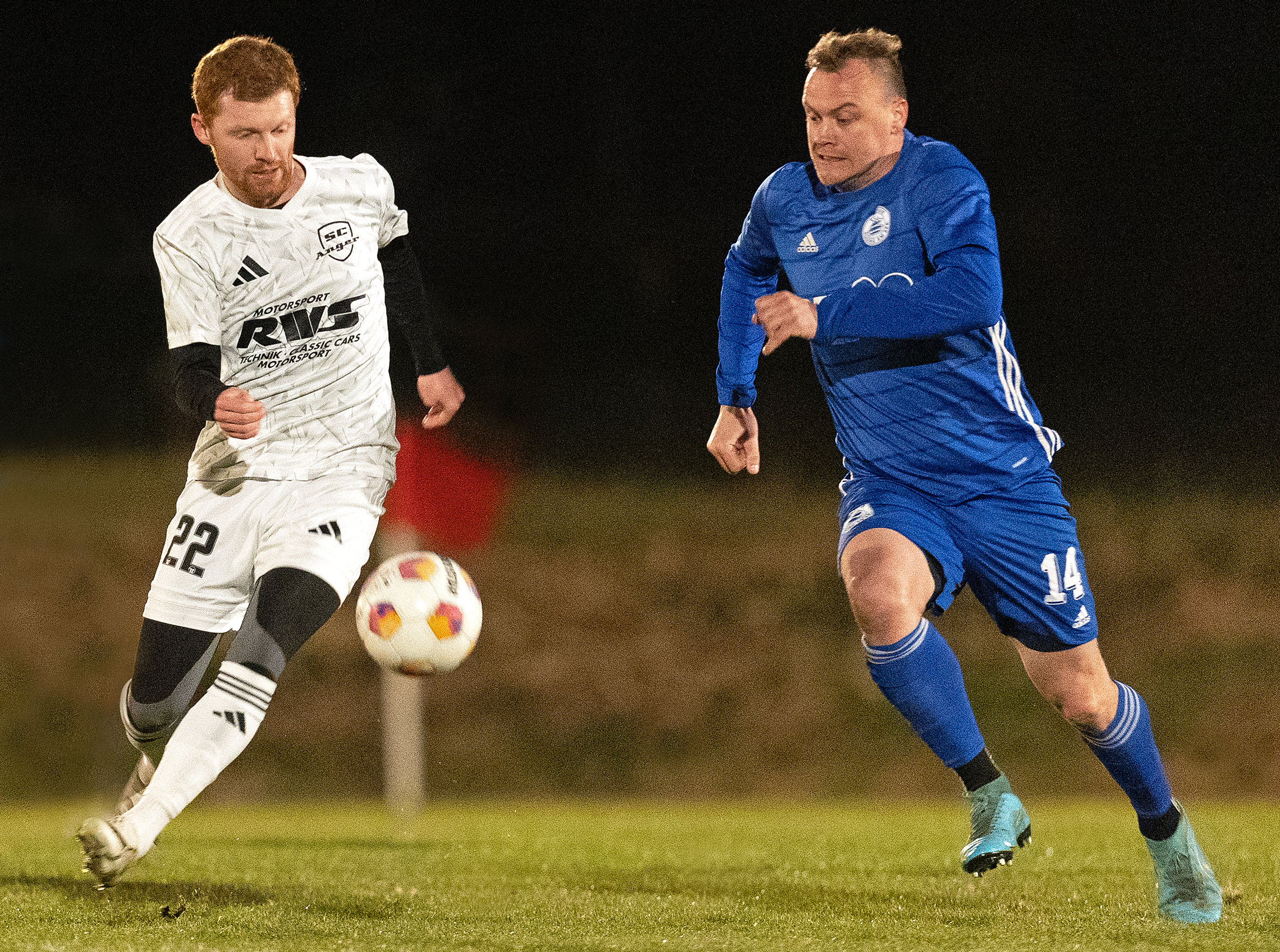 Angers Tom Berger (links), der mit einem Traum-Freistoß den 1:1-Ausgleich und -Endstand erzielte, im Leder-Wettstreit gegen Wagings Andreas Kamml ((C) Hans-Joachim Bittner).